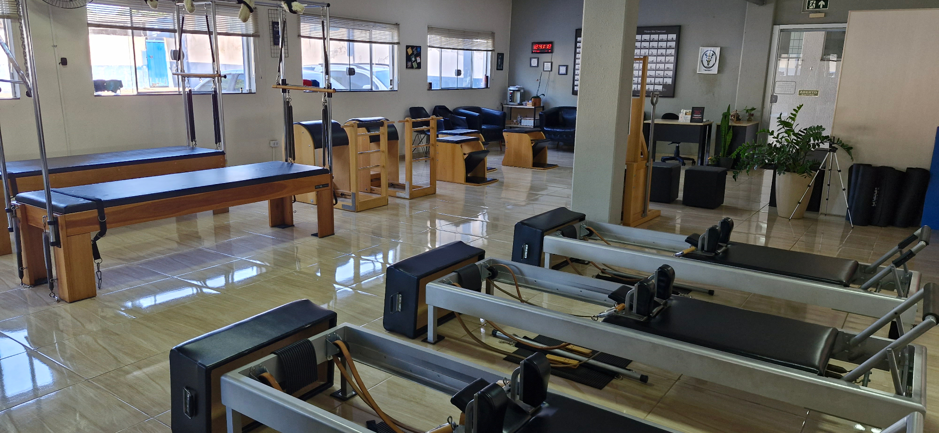 Sala do estúdio com reformers, Cadillac e barrel de Pilates Clássico